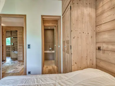a bedroom with a bed with a wooden wall at Appartement 3P 6 pers. proche pistes, wifi, garage - FR-1-453-293 in Megève