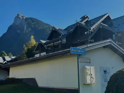 a building with a blue street sign in front of it at Studio rénové au centre avec balcon et parking - FR-1-624-106 in Samoëns