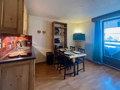 a kitchen with a table and chairs in a room at Studio rénové au centre avec balcon et parking - FR-1-624-106 in Samoëns