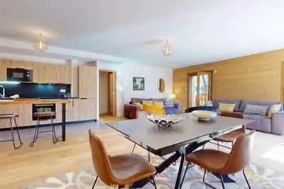 a kitchen and living room with a table and chairs at Les Carlines 09 in Samoëns