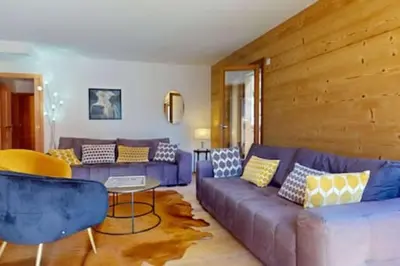 a living room with a purple couch and a table at Les Carlines 09 in Samoëns