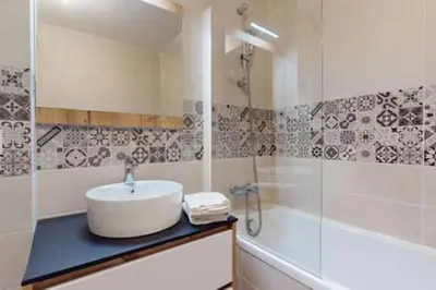 a bathroom with a sink and a shower and a tub at Les Carlines 09 in Samoëns