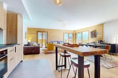 a kitchen and living room with a table and chairs at Les Carlines 09 in Samoëns