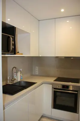 a kitchen with white cabinets and a sink and a microwave at LE YAMA in Chamonix-Mont-Blanc