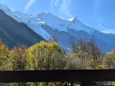 a view of a snowy mountain range with a bench at LE YAMA in Chamonix-Mont-Blanc