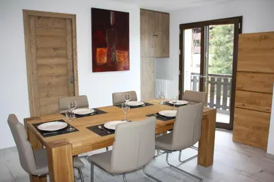 a dining room with a wooden table and chairs at LE YAMA in Chamonix-Mont-Blanc