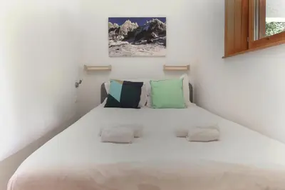 a bedroom with a large white bed with two pillows at Chalet Kandahar - Piscine intérieure - Parc & Lac des Chavants - Escalade - Sentiers de Randonnée in Les Houches