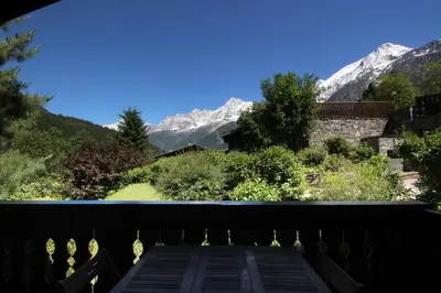 a view of mountains from the balcony of a house at Chalet Kandahar - Piscine intérieure - Parc & Lac des Chavants - Escalade - Sentiers de Randonnée in Les Houches