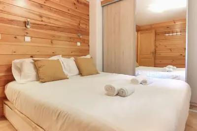 a bedroom with a white bed with towels on it at Chalet Kandahar - Piscine intérieure - Parc & Lac des Chavants - Escalade - Sentiers de Randonnée in Les Houches