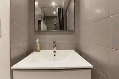 a bathroom with a white sink and a mirror at Chalet Kandahar - Piscine intérieure - Parc & Lac des Chavants - Escalade - Sentiers de Randonnée in Les Houches