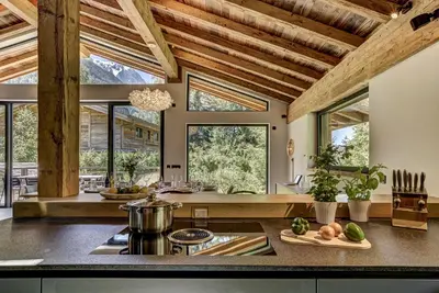 a kitchen with wooden ceilings and windows and a counter at Chalet Black Stone in Chamonix-Mont-Blanc