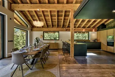 a dining room with a table and a kitchen at Chalet Black Stone in Chamonix-Mont-Blanc