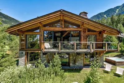 a log home with a large deck with glass doors at Chalet Black Stone in Chamonix-Mont-Blanc