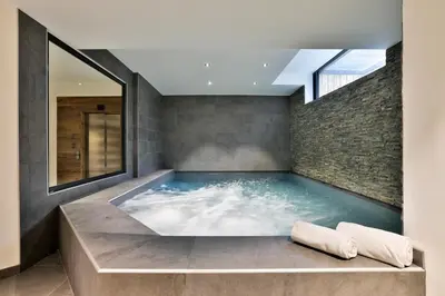 a hot tub in a room with a brick wall at Chalet Black Stone in Chamonix-Mont-Blanc