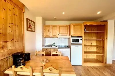 a kitchen with wooden cabinets and a wooden table at Reflet du Mont-Blanc in Combloux