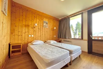 two beds in a room with wood paneled walls at Reflet du Mont-Blanc in Combloux