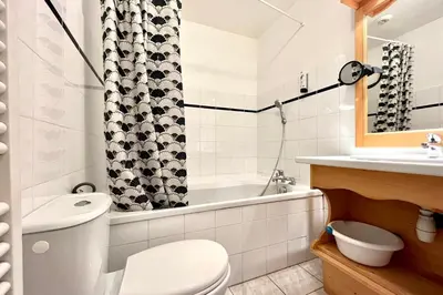a bathroom with a toilet and a tub and a sink at Reflet du Mont-Blanc in Combloux