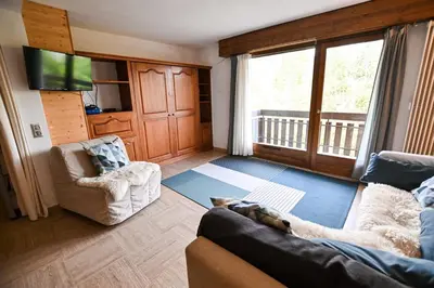 a living room with a couch and chairs and a tv at Panoramic Megève in Megève