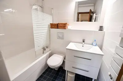a white bathroom with a toilet and a sink at Panoramic Megève in Megève