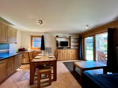 a kitchen with a table and a dining room at Appartement T2 avec grande terrasse et animaux acceptés - FR-1-624-105 in Samoëns