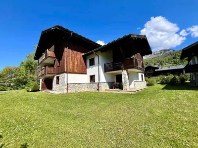 a house in a field with a grass yard at Appartement T2 avec grande terrasse et animaux acceptés - FR-1-624-105 in Samoëns