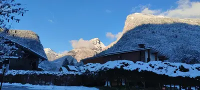 a building with snow on it in front of a mountain at DOMAINE DU GRAND TETRAS SAMOENS in Samoëns