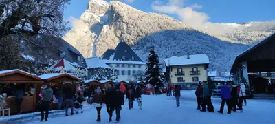 a group of people walking through a town in the snow at DOMAINE DU GRAND TETRAS SAMOENS in Samoëns