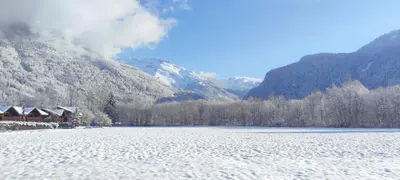 a snow covered lake in front of a mountain at DOMAINE DU GRAND TETRAS SAMOENS in Samoëns