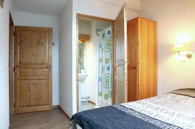a bedroom with a bed and a closet and a door at Saint-Gervais apartment next to Bettex ski lift in Saint-Gervais-les-Bains