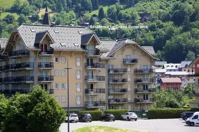 a large apartment building with cars parked in a parking lot at Saint-Gervais apartment next to Bettex ski lift in Saint-Gervais-les-Bains