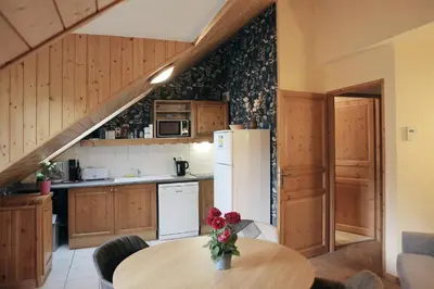 a kitchen with a table and a refrigerator at Saint-Gervais apartment next to Bettex ski lift in Saint-Gervais-les-Bains