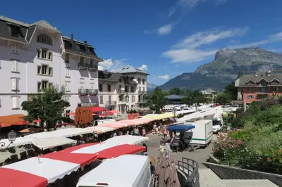 a street with umbrellas and buildings with a mountain in the background at Saint-Gervais apartment next to Bettex ski lift in Saint-Gervais-les-Bains