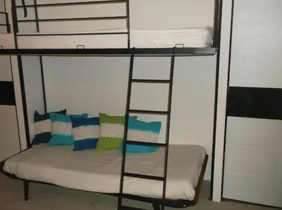 a bunk bed in a room with a bed and a ladder at Appartement Résidence Astoria in Chamonix-Mont-Blanc