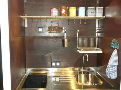 a kitchen with a stainless steel sink and a stove at Appartement Résidence Astoria in Chamonix-Mont-Blanc