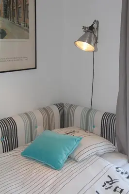 a bed with a blue pillow and a lamp at Appartement Résidence Astoria in Chamonix-Mont-Blanc