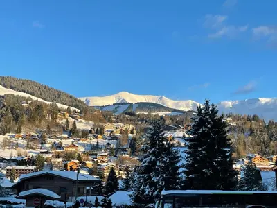 a town covered in snow with mountains in the background at Megève - Chalet Yack - Premium jusqu'à 15 pers in Megève