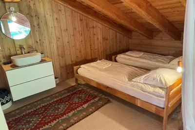 a bedroom with two beds and a sink in a cabin at Semi Detached Chalet For 8 With Balcony & Garden in Chamonix-Mont-Blanc