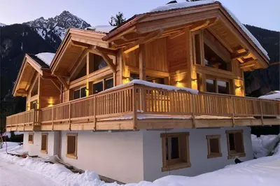 a bedroom with a large window in a wooden cabin at Semi Detached Chalet For 8 With Balcony & Garden in Chamonix-Mont-Blanc