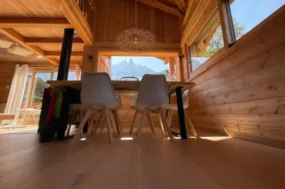 a wooden cabin with a table and chairs on a deck at Semi Detached Chalet For 8 With Balcony & Garden in Chamonix-Mont-Blanc