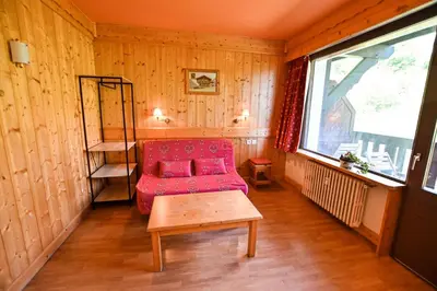 a living room with a red couch and a window at Bright Studio With Balcony in Combloux