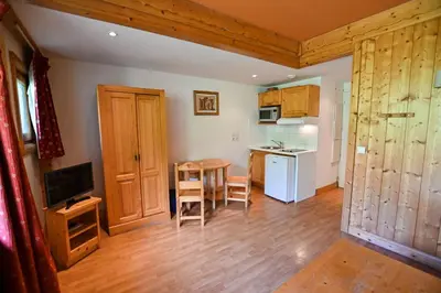 a living room with a kitchen and a table at Bright Studio With Balcony in Combloux