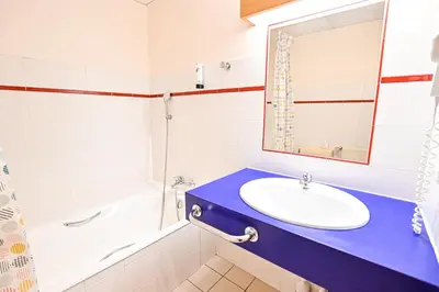 a bathroom with a sink and a tub and a mirror at Bright Studio With Balcony in Combloux