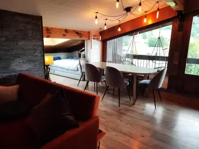 a living room with a table and chairs and a bed at Appartement en plein centre du village (6-8 personnes) in Les Contamines-Montjoie