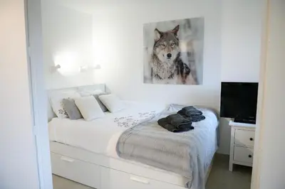 a bedroom with a bed with a picture of a wolf at Chamonix 27 - Au Centre Vue Mont Blanc et Jardin in Chamonix-Mont-Blanc