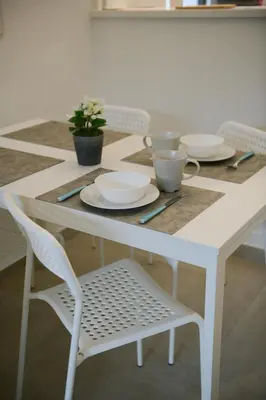 a white table with plates and cups on it at Chamonix 27 - Au Centre Vue Mont Blanc et Jardin in Chamonix-Mont-Blanc