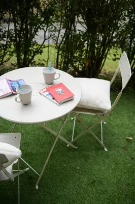 a white table with two cups and a book on it at Chamonix 27 - Au Centre Vue Mont Blanc et Jardin in Chamonix-Mont-Blanc