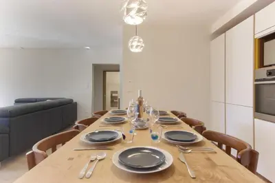 a dining room with a wooden table with plates and silverware at L'Abeille - Renovated - 4 bedroom - 8 person-110sqm - Views! in Les Houches