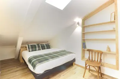 a small bedroom with a bed and a chair at L'Abeille - Renovated - 4 bedroom - 8 person-110sqm - Views! in Les Houches