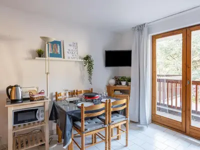 a small kitchen with wooden cabinets and a bunk bed at Apartment Le Martagon 007 by Interhome in Saint-Gervais-les-Bains