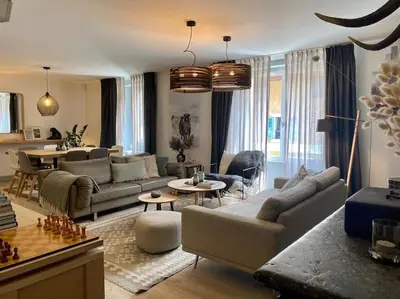 a living room with couches and a dining room at Appartement Mocca au coeur de Chamonix Mont-Blanc in Chamonix-Mont-Blanc